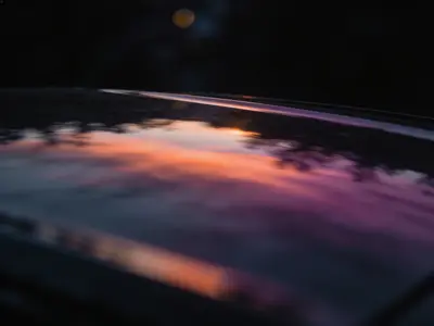 A phone on a dark surface glowing with coloured light