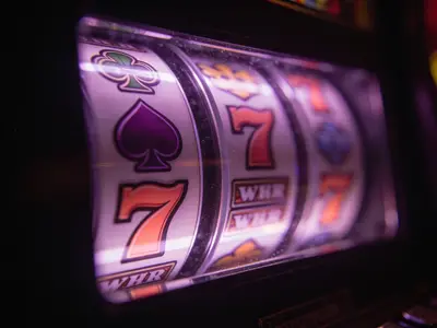 Slot reel symbols lit behind glass in a dark room
